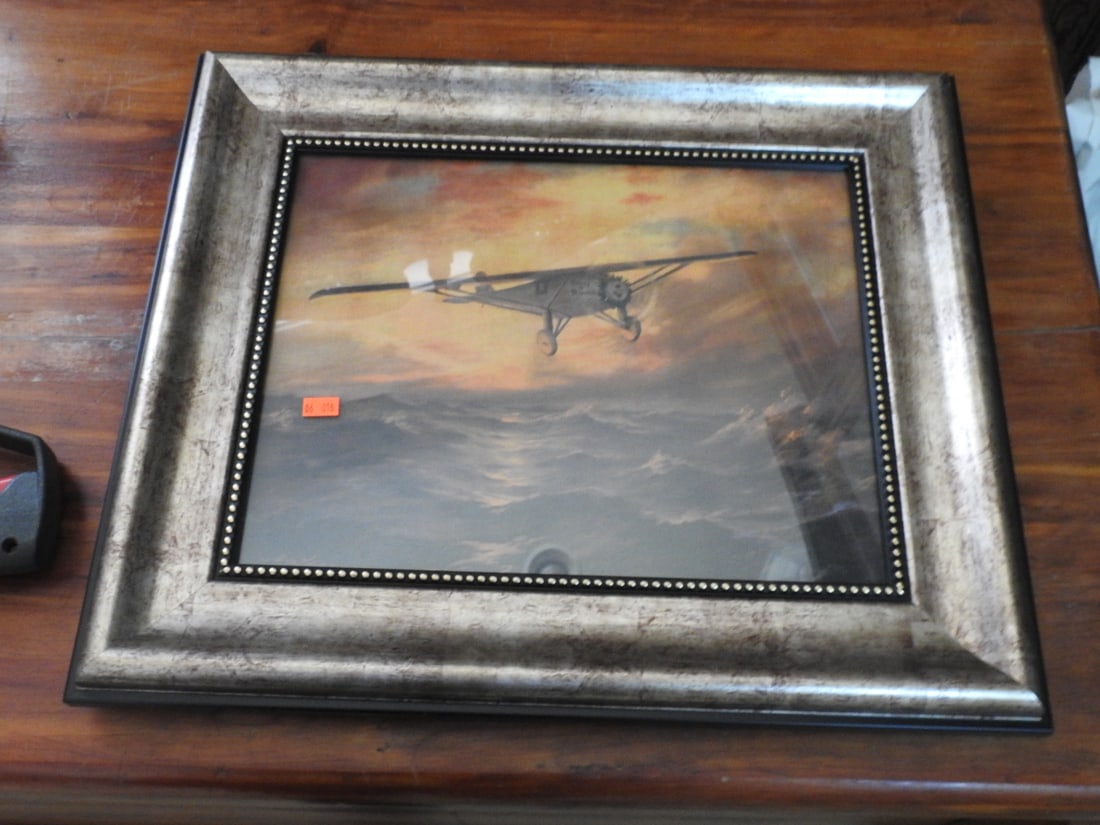 Spirit of St. Louis Framed Aviation Reprint: Framed aviation reprint titled Spirit of St. Louis, depicting an airplane in flight, housed in a silver-tone frame. Approx. 16.5 x 20 x 2 in.
