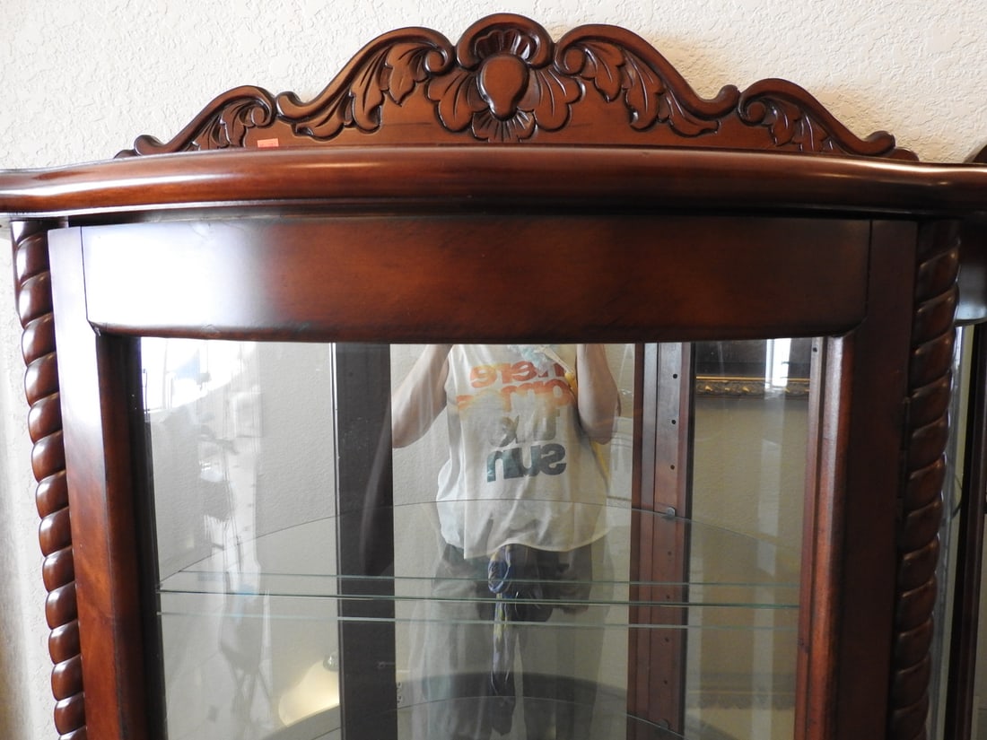 Classical Style Half-Round Glass Curio Cabinet: Classical style half-round curio cabinet with rounded glass front, glass shelving, mirror backing, and carved-style wood frame. Approx. 68 x 34 x 15 in.