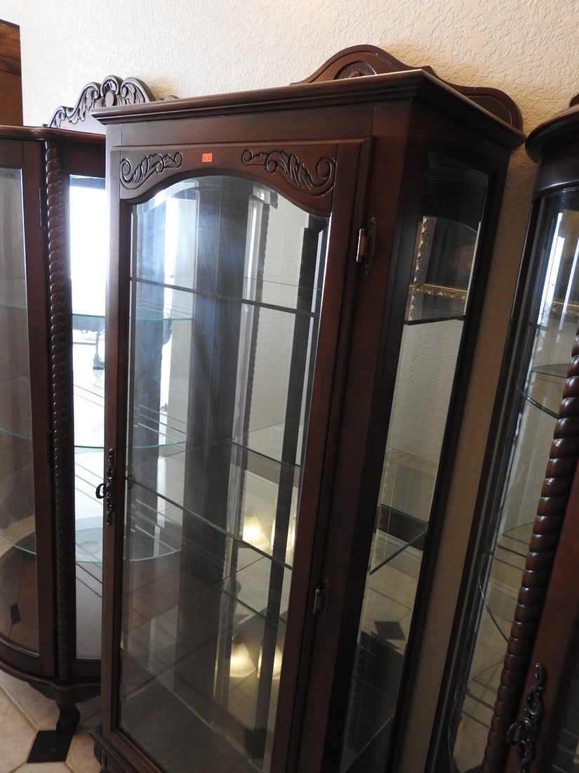 Classical Style Glass Curio Cabinet: Classical style glass curio cabinet with wood frame, glass shelving, mirror backing, and carved decorative apron. Approx. 68 x 27 x 14 in.