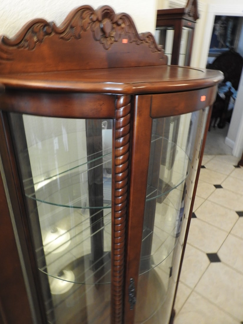 Classical Style Half-Round Glass Curio Cabinet: Classical style half-round curio cabinet with rounded glass front, glass shelving, mirror backing, and carved-style wood frame. Approx. 68 x 34 x 15 in.