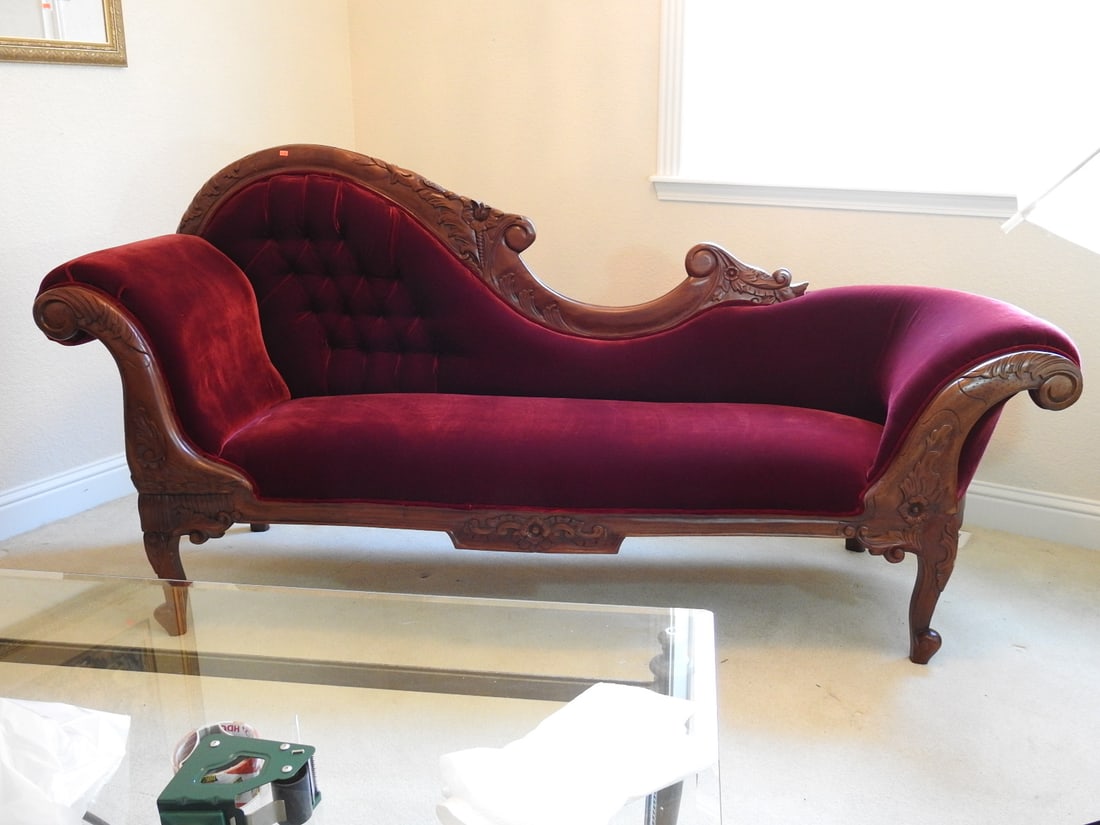 Vintage Victorian Style Red Velvet Chaise Lounge: Vintage Victorian style chaise lounge with walnut-stained carved wood frame and red velvet tufted upholstery. Approx. 41 x 80 x 28 in.