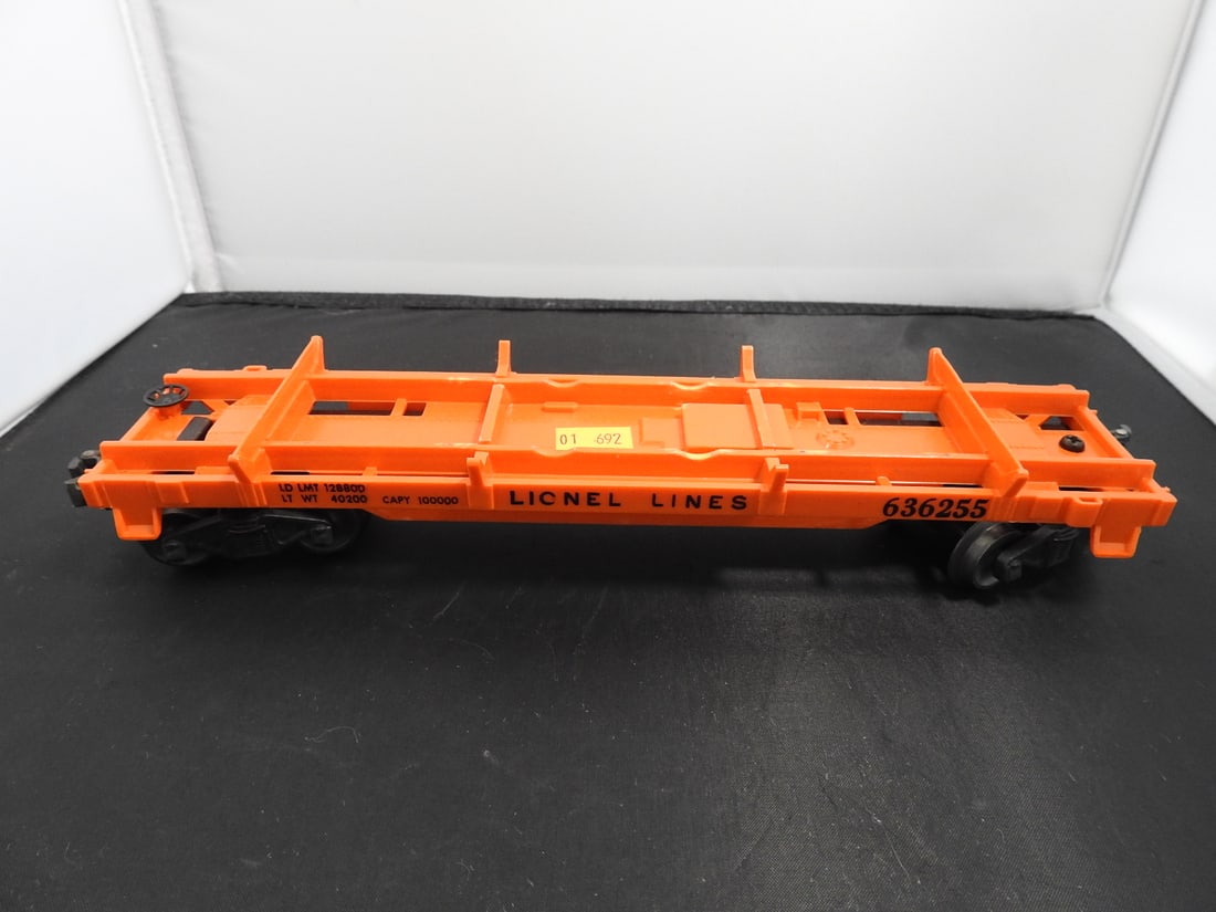 Lionel No. 6362 Railway Truck Flatcar: Lionel postwar-era O gauge No. 6362-55 railway truck flatcar with orange deck, grey railway truck load, metal frame, and operating couplers. Circa 1950s Lionel production. Approx. 2 x 11.5 x 2.75 in.