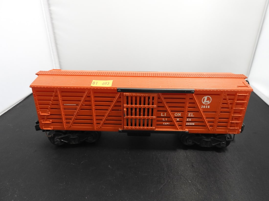 Lionel No. 3656 Operating Cattle Car: Lionel postwar-era O gauge No. 3656 operating cattle car in orange with slatted sides, sliding doors, black trucks/couplers, and metal frame. Circa 1950s Lionel production; operating feature not fully