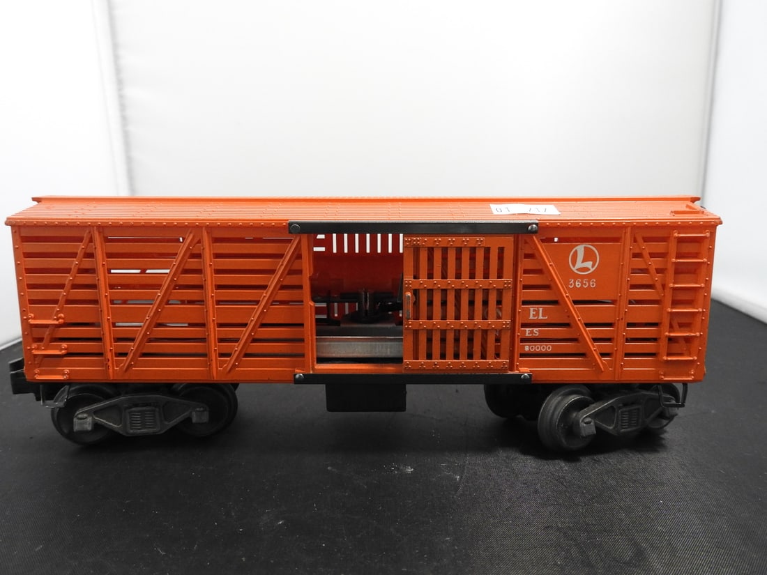 Lionel No. 3656 Operating Cattle Car: Lionel postwar-era O gauge No. 3656 operating cattle car in orange with slatted sides, sliding door, black frame, and operating couplers. Circa 1950s Lionel production; operating feature not fully