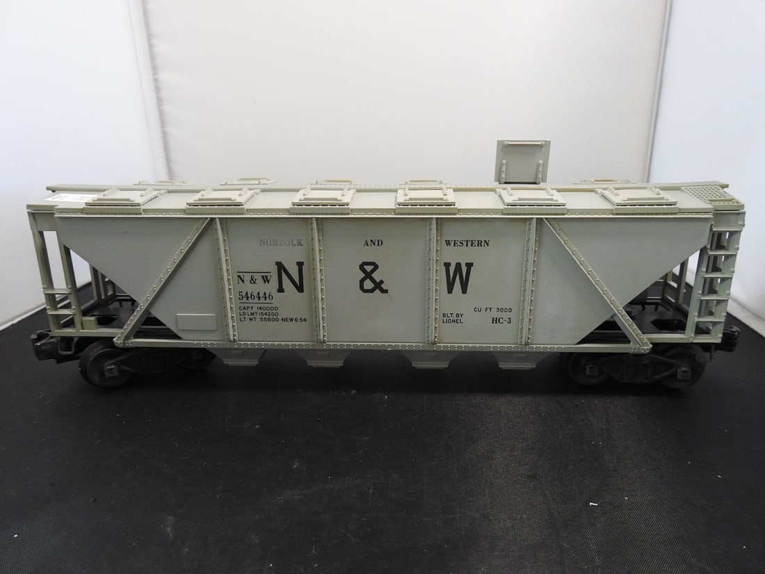 Lionel Norfolk & Western 546446 Covered Hopper Car: Lionel O gauge Norfolk & Western covered hopper car No. 546446 with grey body, top hatches, N&W markings, and black trucks. Side lettering includes NEW 6-54 marking; postwar-style, 1950s-era railroad