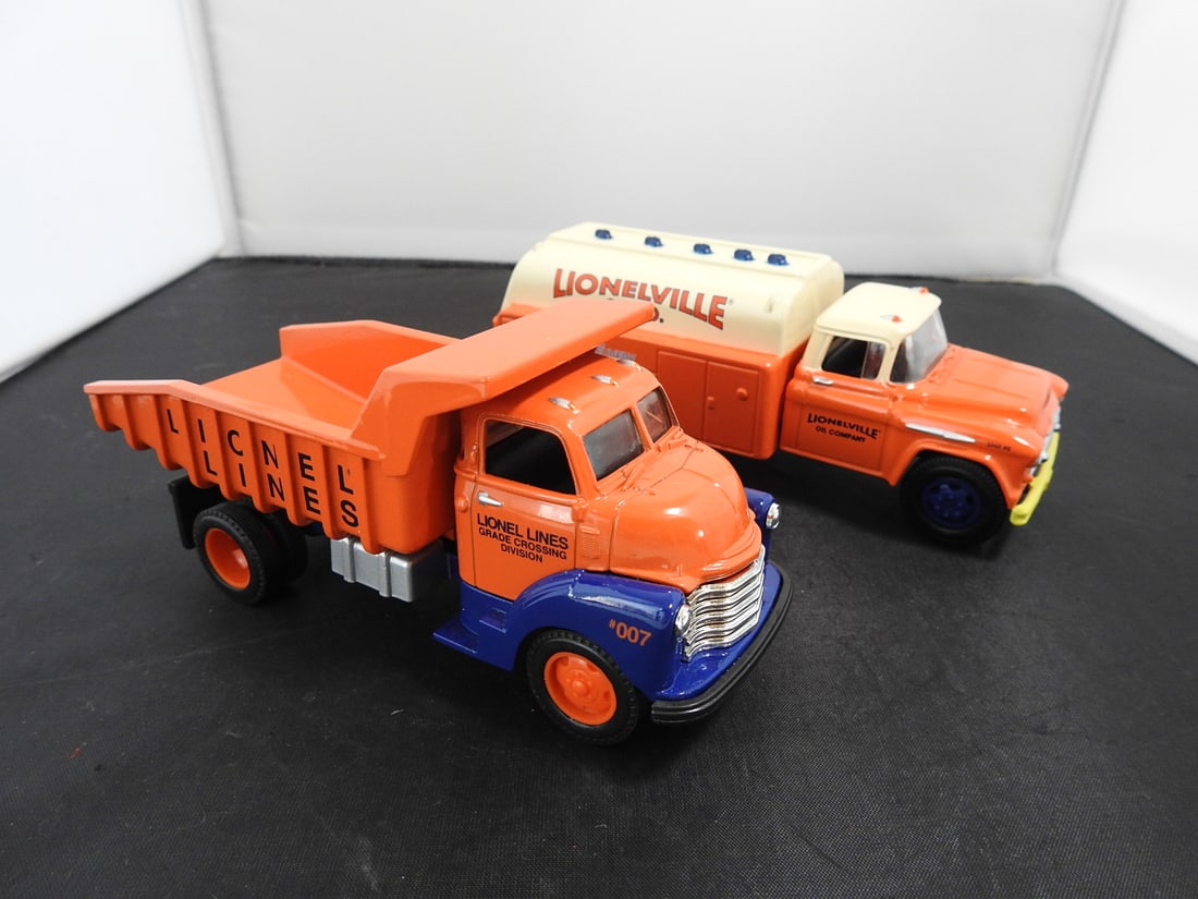 Lot of Two Lionelville Die-Cast Trucks: Lot of two Lionelville die-cast trucks including an orange/blue Lionel Lines Grade Crossing Division dump truck No. 007 and an orange/cream Lionelville Oil Company tanker truck marked Unit 46. Late