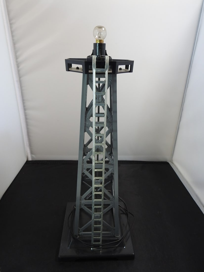 Lionel Floodlight / Beacon Tower Accessory: Lionel floodlight / beacon tower accessory with gray truss tower, single bulb socket, and square base. Vintage Lionel train layout accessory, mid-20th century style. Approx. 12.5 x 4.75 x 5.75 in.