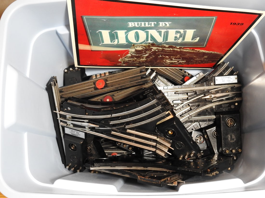 Tub of Lionel Train Track, Remote Controls and Train Signs: Tub lot of Lionel train track, remote controls, train signs, and assorted model railroad layout components. Mixed vintage and later Lionel-compatible parts, measured as packed. Approx. 16.5 x 24.25 x 