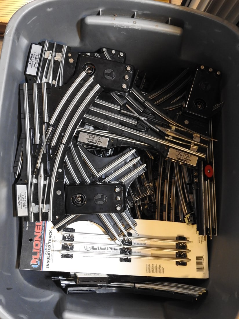 Tub of Lionel Train Track, Remote Controls and Track Switches: Tub lot of Lionel train track, remote controls, track switches, and assorted model railroad layout components. Mixed vintage and later Lionel-compatible parts, measured as packed. Approx. 15.25 x 23.5