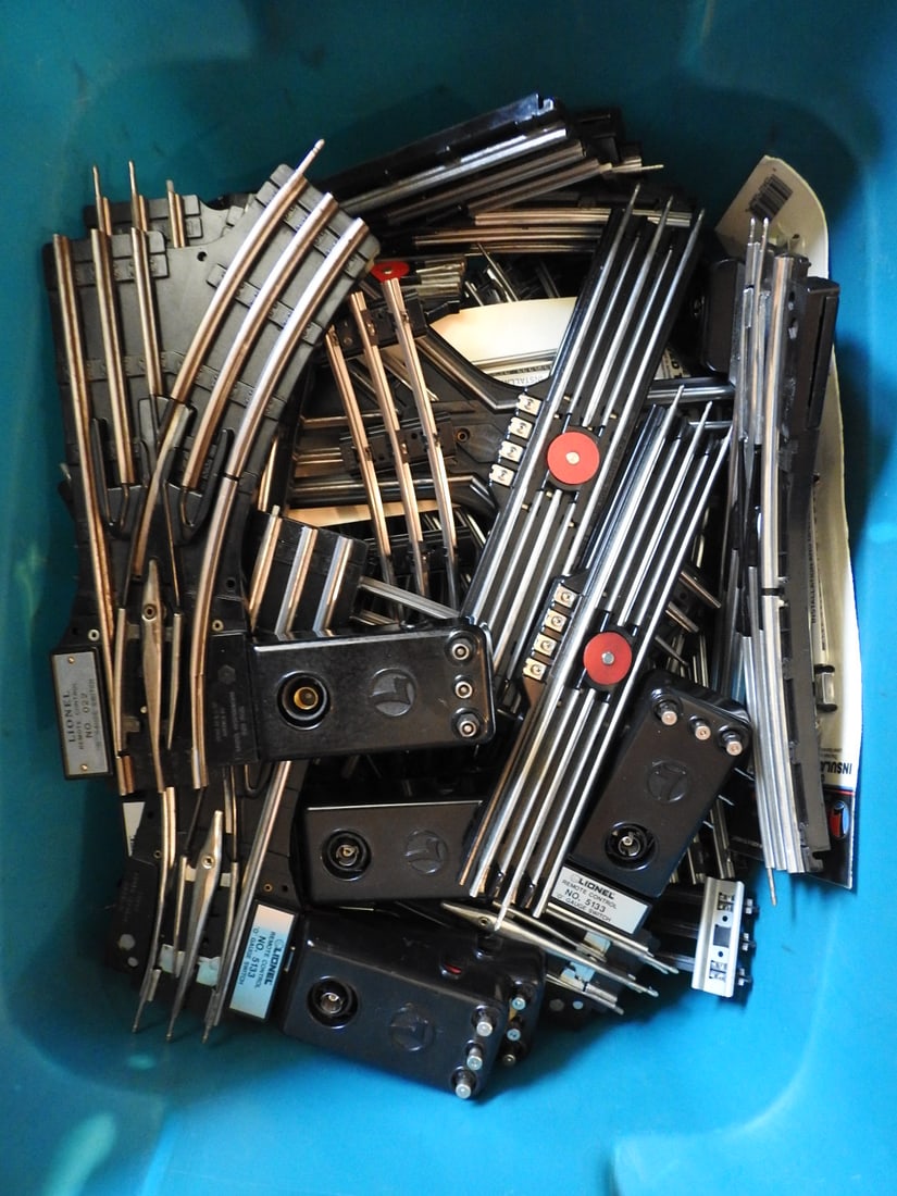 Tub of Lionel Train Track, Remote Controls and Track Switches: Tub lot of Lionel train track, remote controls, track switches, and assorted model railroad layout components. Mixed vintage and later Lionel-compatible parts, measured as packed. Approx. 15.25 x 23.5