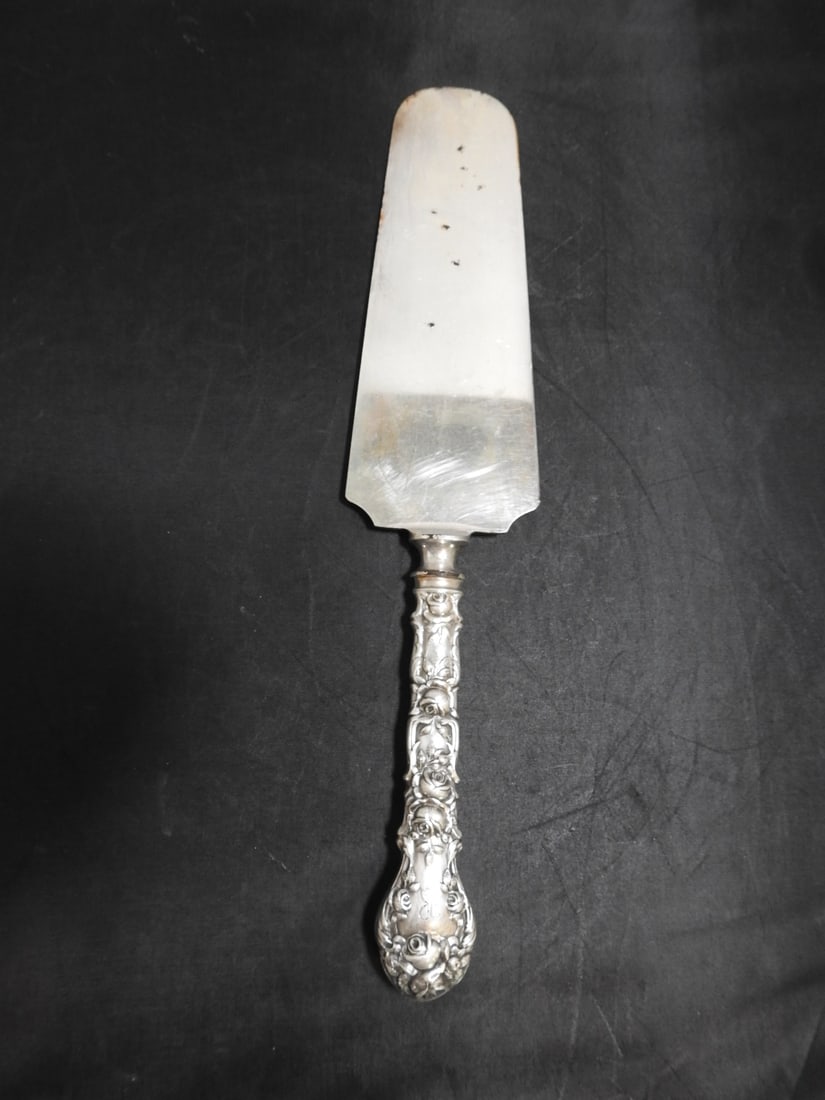 Alvin Bridal Rose Sterling-Handled Cake Server: Sterling-handled cake server in the Bridal Rose pattern by Alvin Silver Co. total weight at 87.61 grams / 3.09 troy oz. and notes a plated blade. Approx. 0.75 x 10.25 x 2.25 in.