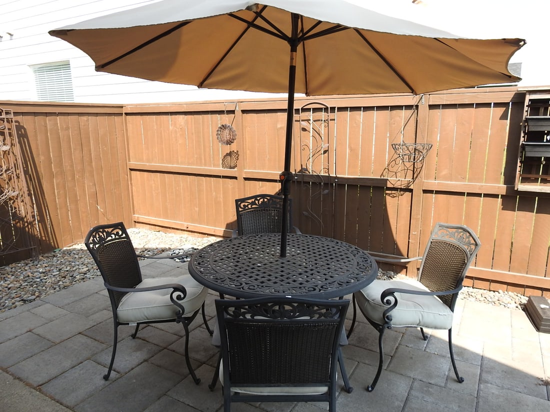 Outdoor Patio Dining Set with Umbrella, Table and Chairs: Outdoor patio dining set with table, chairs, and patio umbrella. Chairs feature plastic rattan-look backs with light cushions. Umbrella measures approx. 93 x 8.5 x 8.8 in.; table approx. 28.5 x 48.5