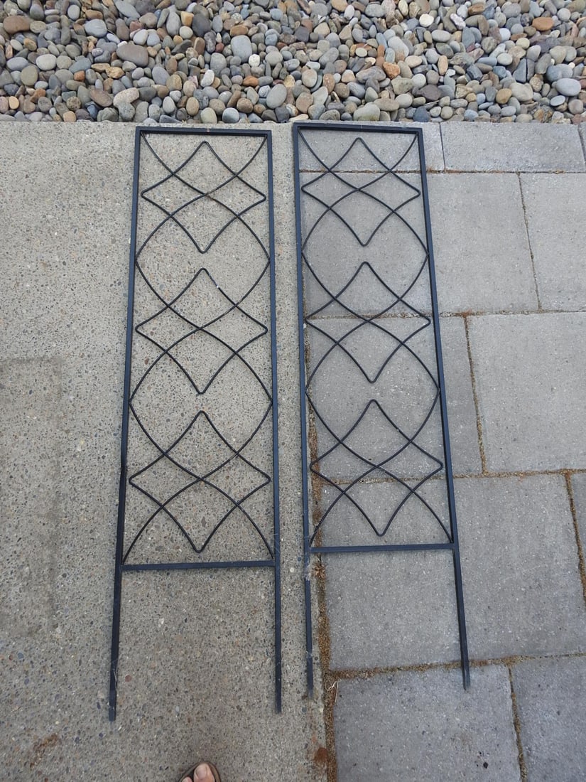 Set of Two Metal Garden Trellises: Set of two metal garden trellises with diamond lattice-style panels and arched top detail. Each measures approx. 48.5 x 12.5 x 0.5 in.