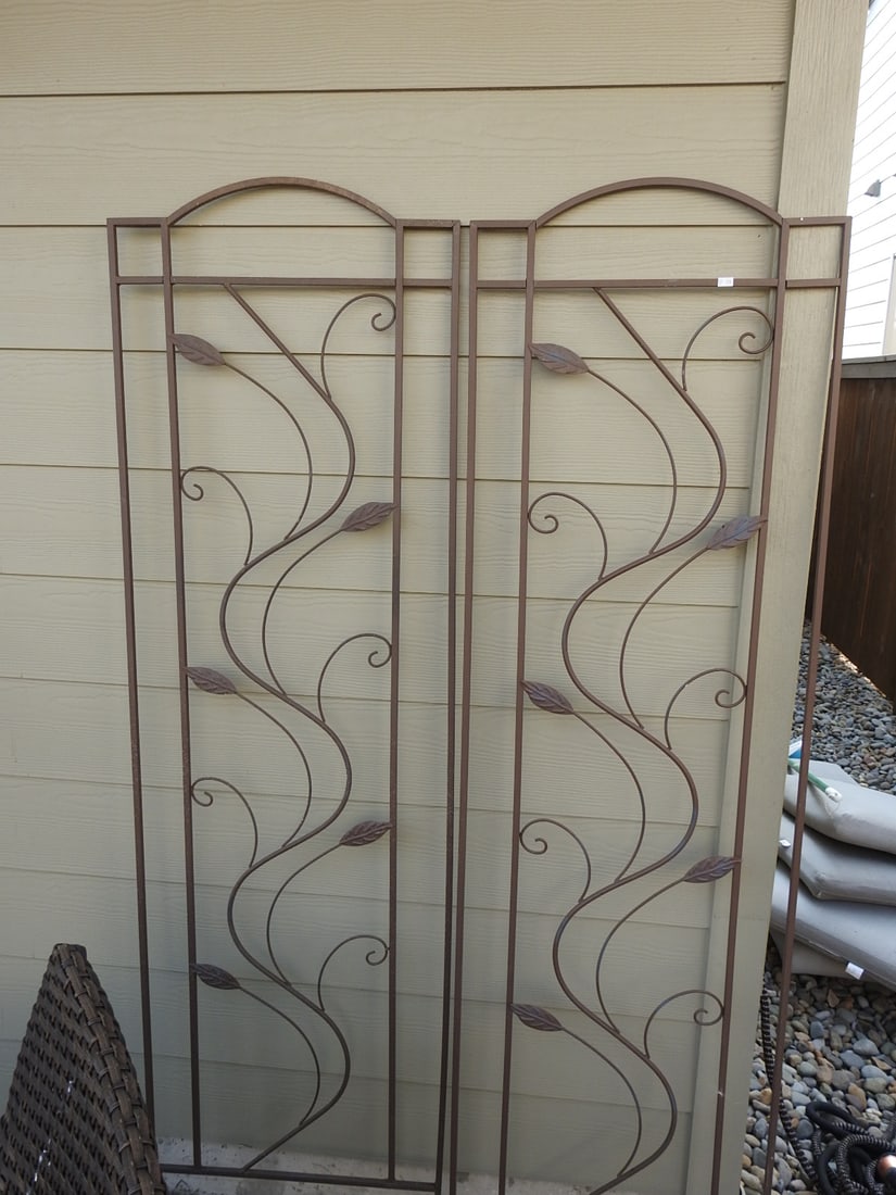 Set of Two Large Metal Garden Trellises: Set of two large metal garden trellises with arched tops, scrollwork, and leaf accents. Each measures approx. 72 x 20 x 0.5 in.