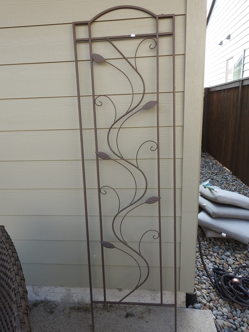 Large Metal Garden Trellis with Scroll and Leaf Detail: Large metal garden trellis with arched top, scrollwork, and leaf accent decoration. Approx. 72 x 20 x 0.5 in.