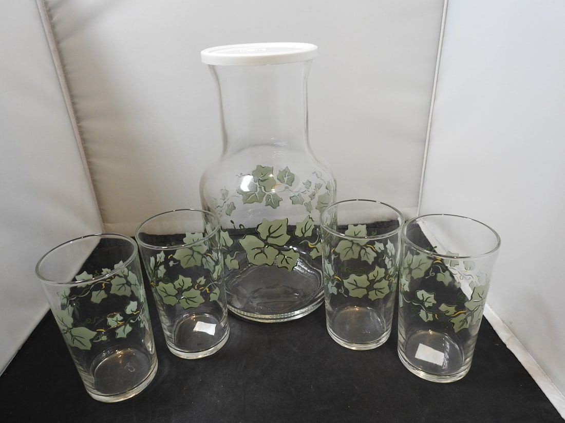 Carafe and Glasses Set: Carafe and glasses set with floral/leaf decoration, measured as packed. Approx. 9 x 5 x 4 in.