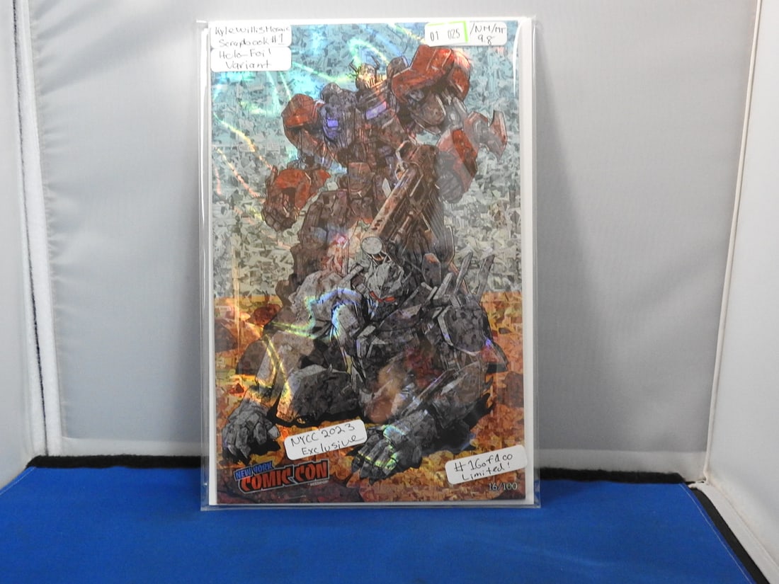 Mosaic Scrapbook #1 Holo-Foil / Rainbow Foil Variant: Mosaic Scrapbook #1 with holo-foil / rainbow foil cover treatment. Comic-Con marking visible on cover.