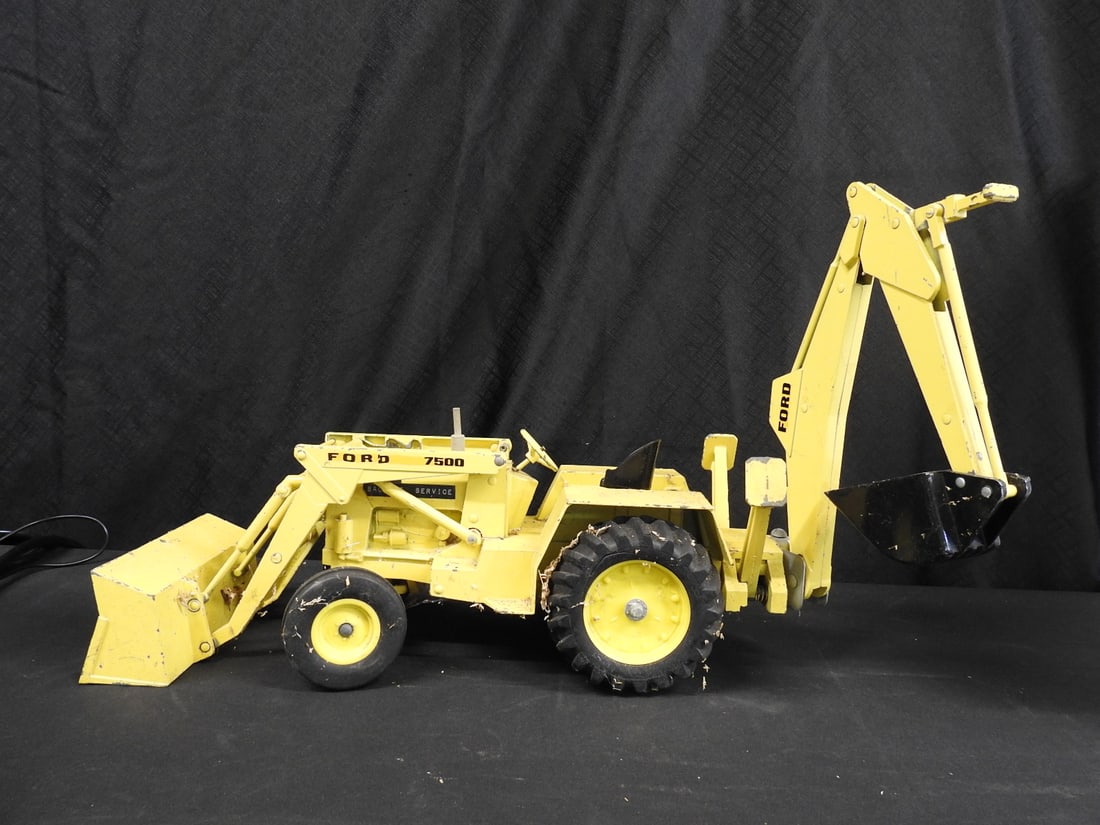 Ford 7500 Backhoe Loader Metal Model: Large yellow Ford 7500 backhoe loader model with articulated front bucket and rear digging arm. Marked Ford 7500; metal construction with rubber tires.