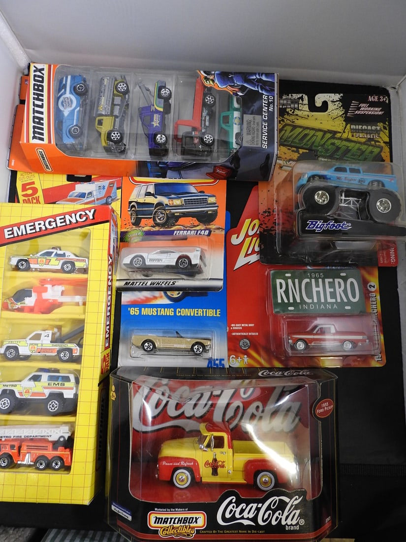 Matchbox, Johnny Lightning and Other Packaged Die-Cast Vehicles: Packaged die-cast assortment including Matchbox Coca-Cola and emergency sets, Johnny Lightning Mustang and Ranchero models, Bigfoot monster truck, Ferrari F40 and other vehicles shown.
