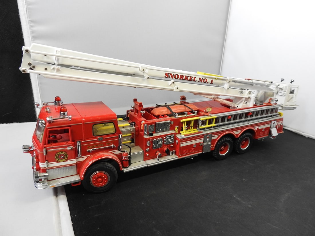 Large Snorkel No. 1 Aerial Fire Truck Model: Large red-and-white Snorkel No. 1 aerial fire truck model with articulated boom and bucket, opening compartments, cab doors and outriggers.