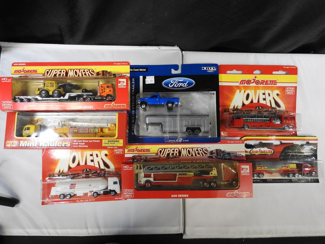 Majorette, Maisto and ERTL Trucks and Fire Vehicles: Seven packaged commercial and emergency vehicle models, including Majorette Super Movers and Movers trucks, Maisto Mini Haulers fire truck, ERTL Ford trailer set, ladder trucks and a tanker.