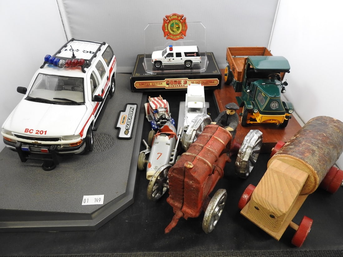 Code 3, Mack and Novelty Vehicle Collectibles: Mixed collectible vehicle group featuring Code 3 Suburban and police models, a Mack truck, cast-metal tractor, wooden log vehicle, micro racer and additional pieces shown.