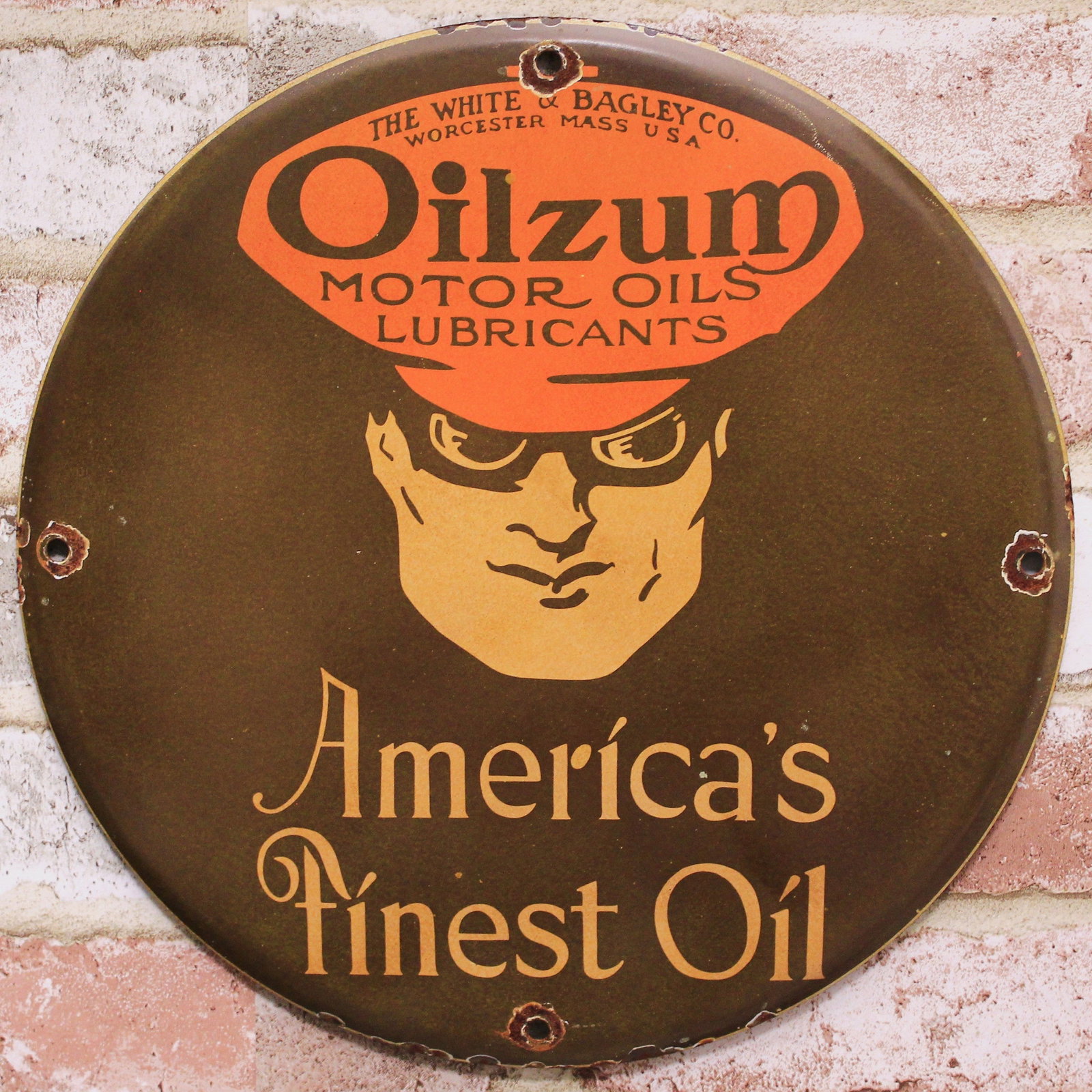 Oilzum America's Finest Oil 12-Inch Porcelain Enamel Sign Reproduction: 12-inch Oilzum America's Finest Oil porcelain enamel advertising sign; handcrafted vintage-style reproduction. The Oilzum driver portrait sits below the motor-oil emblem, with America's Finest Oil let