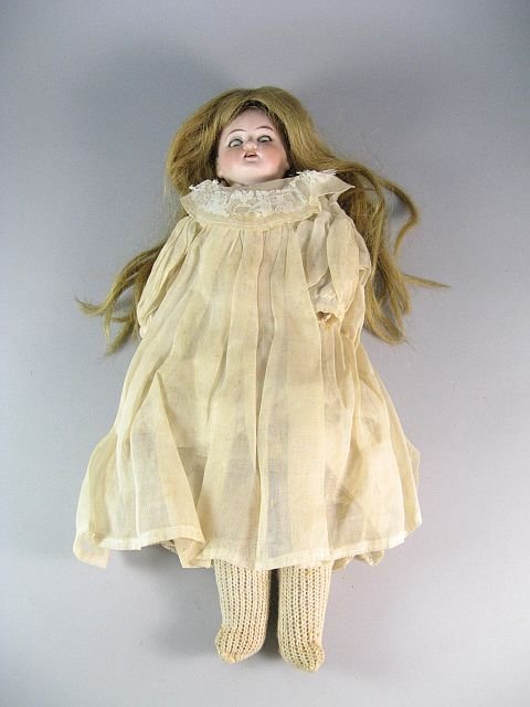 Made In Germany Bisque Doll With Unidentified Mark: H.16". Cloth stuffed legs. Eyes openm