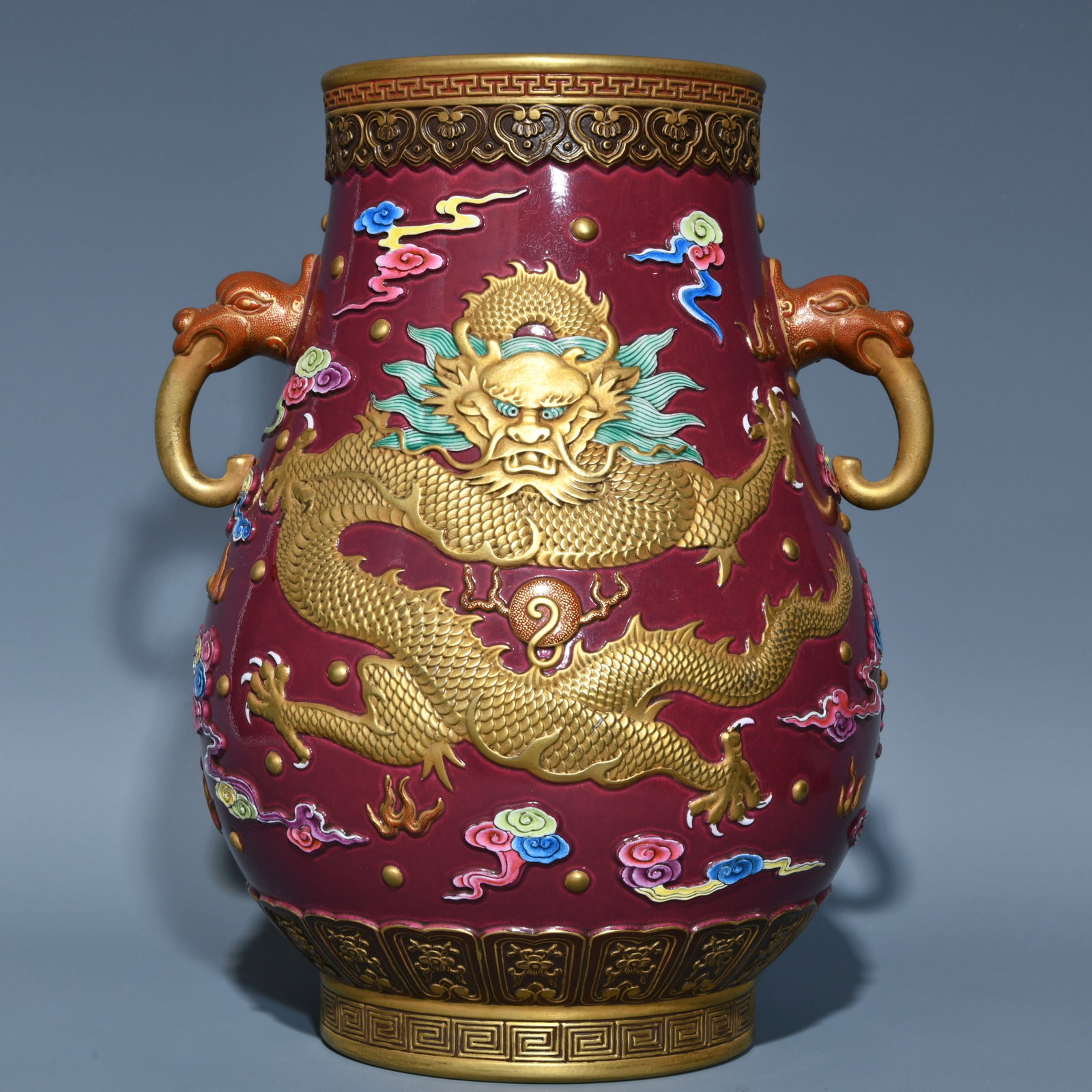 An exquisite chinese rouge ground relief gilt and pastel cloud and dragon pattern elephant ear zun: Size: Height 27.5 cm - Width 21.5 cm |Materials: Porcelain |Style Dynasty: Qing dynasty |Attributed: Qianlong Mark |Object: Chinese Antique