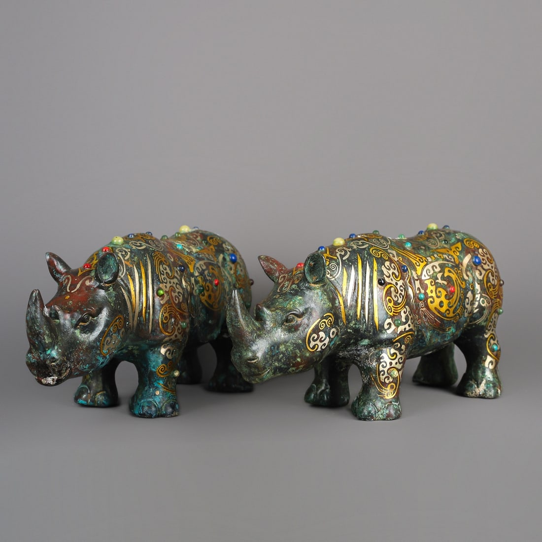 An Exquisite Chinese Pair of bronze and gold inlaid rhinos: Size: Height 12.5 cm - Width 27 cm Materials: Bronze Dynasty: Han dynasty Attribution: 1st to 3rd-C Object: Bell