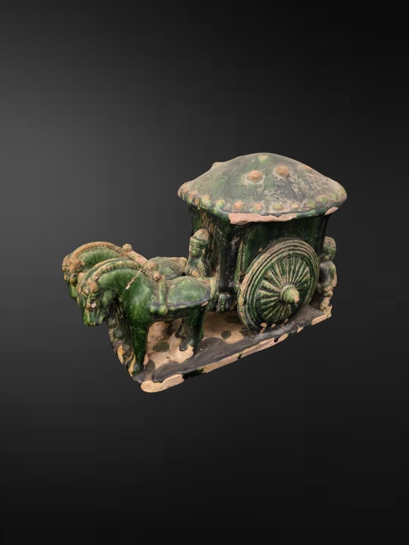 Chinese Green-Glazed Pottery Model of a Covered Carriage with Driver and Ponies: An evocative Chinese green lead-glazed earthenware funerary model (mingqi) of a covered travelling carriage, the enclosed cab surmounted by a domed canopy roof applied with bosses and set between two 