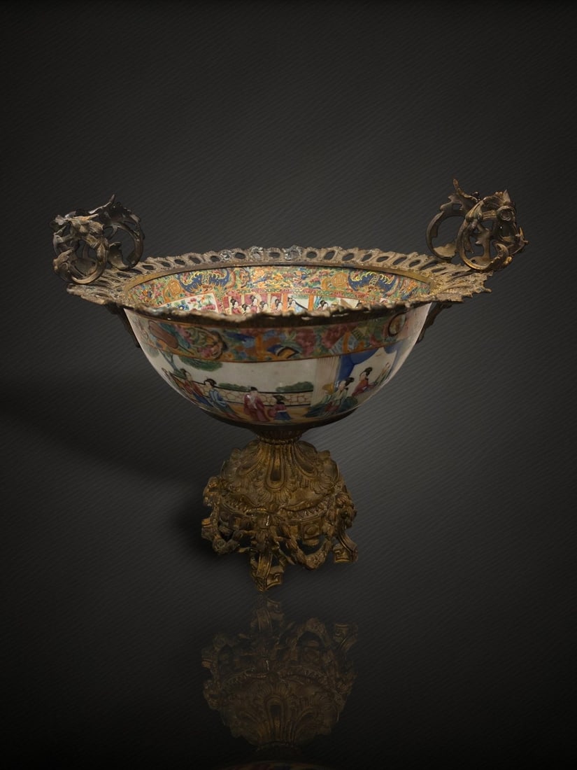 A Chinese Canton Famille Rose 'Figural' Bowl with Gilt-Metal Mounts: A rose-medallion type porcelain bowl decorated in famille rose enamels, mounted in a European-style gilt-metal frame to form a footed centrepiece or tazza. The porcelain is painted with reserved panel