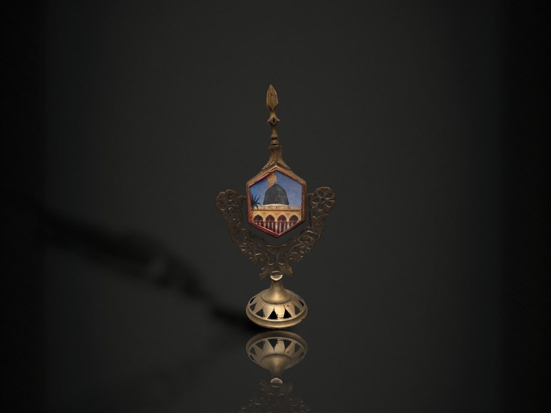 A Pair of Brass 'Holy Sites' Miniature Frame Ornaments: A pair of small ornamental table stands of cast and pierced yellow metal, apparently brass. Each takes the form of a hexagonal picture cartouche flanked by openwork foliate scroll wings and surmounted