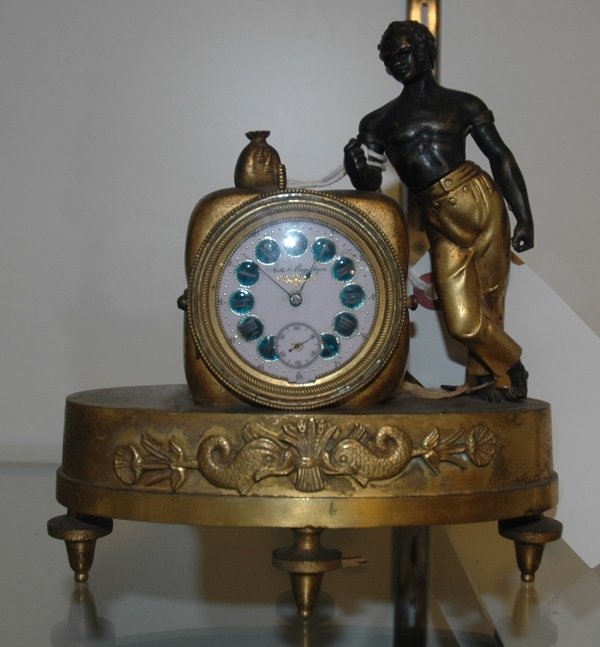 19TH CENTURY RESTAURATION STYLE MANTEL CLOCK: PATINATED- METAL AND GILT-BRONZE, IN THE FORM OF A BLACKAMOOR FIGURE WITH COTTON BALE Measurements: L 7"