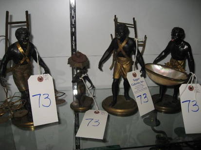 A GROUP OF FOUR PAINTED BLACKAMOOR FIGURES: GILT- METAL, COMPRISING AN EXAMPLE HOLDING A SHELL, 2 EXAMPLES WITH BOTTLE HOLDERS AND AN EXAMPLE WITH AN UMBRELLA Measurements: H 10 1/2"