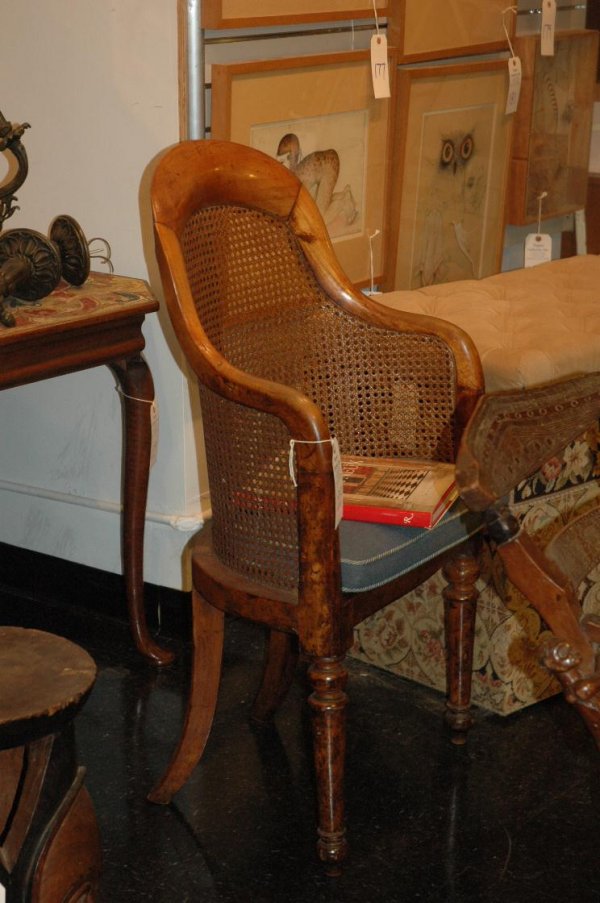 A MID 19TH CENTURY MAHOGANY AND CANED BERGERE: RAISED ON TALL TURNED LEGS