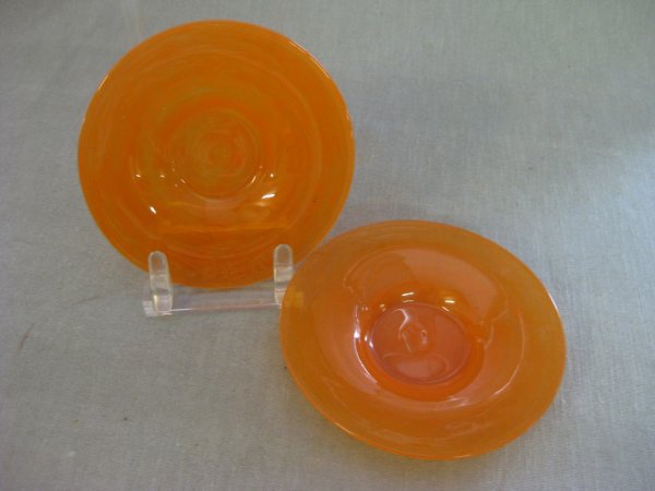 A PAIR OF TWO VENINI ORANGE PLATES, free blown pan o: A PAIR OF TWO VENINI ORANGE PLATES, free blown pan or shallow bowl. Delicate pan form with a pronounced circular foot drawn from the same glass gather, brilliant medium burnt orange , inward rolled mo