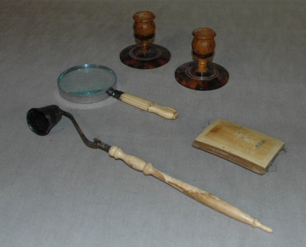 A GROUP OF FIVE IVORY AND TORTOISE SHELL ITEMS, in: A GROUP OF FIVE IVORY AND TORTOISE SHELL ITEMS, including a pair of tortoise candle holders, an ivory sewing kit, and ivory magnifying glass and an ivory candle snuffer. Longest 11"