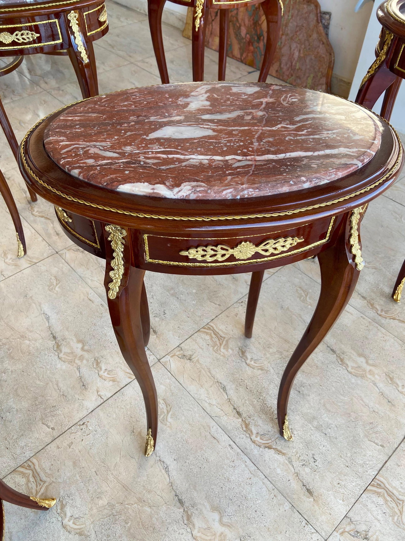 Pair of French Louis XV Oval End Tables: COMING SOON - RESERVE NOW Only one pair available. Elevate your interior with this magnificent pair of French Louis XV side tables, handcrafted from solid mahogany and adorned with exquisite gilt bron