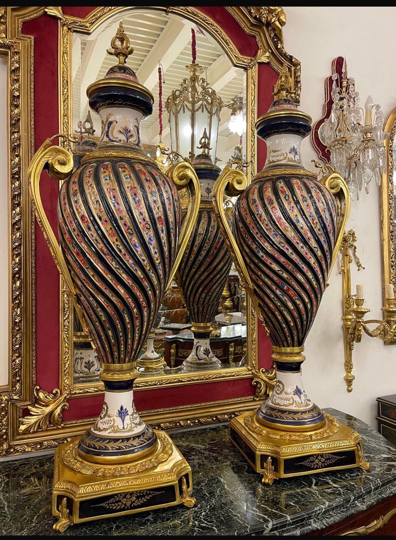 Monumental French Empire Porcelain Urns: DIMENSIONS (Each) - Height: 55 inches - Width: 20 inches Transform your interior with this breathtaking pair of oversized French Empire-style decorative urns, featuring richly detailed hand-painted fl