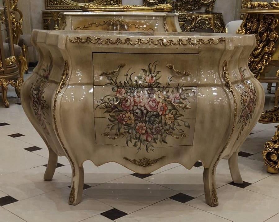 Sculptural Louis XV Bombe Commode Hand Painted: 49.6" W x 19.7" D x 30.3" H This exceptional French Rococo piece showcases dramatic curved sides, a richly hand-finished cream lacquer appearance, and beautifully painted floral bouquets that add warm