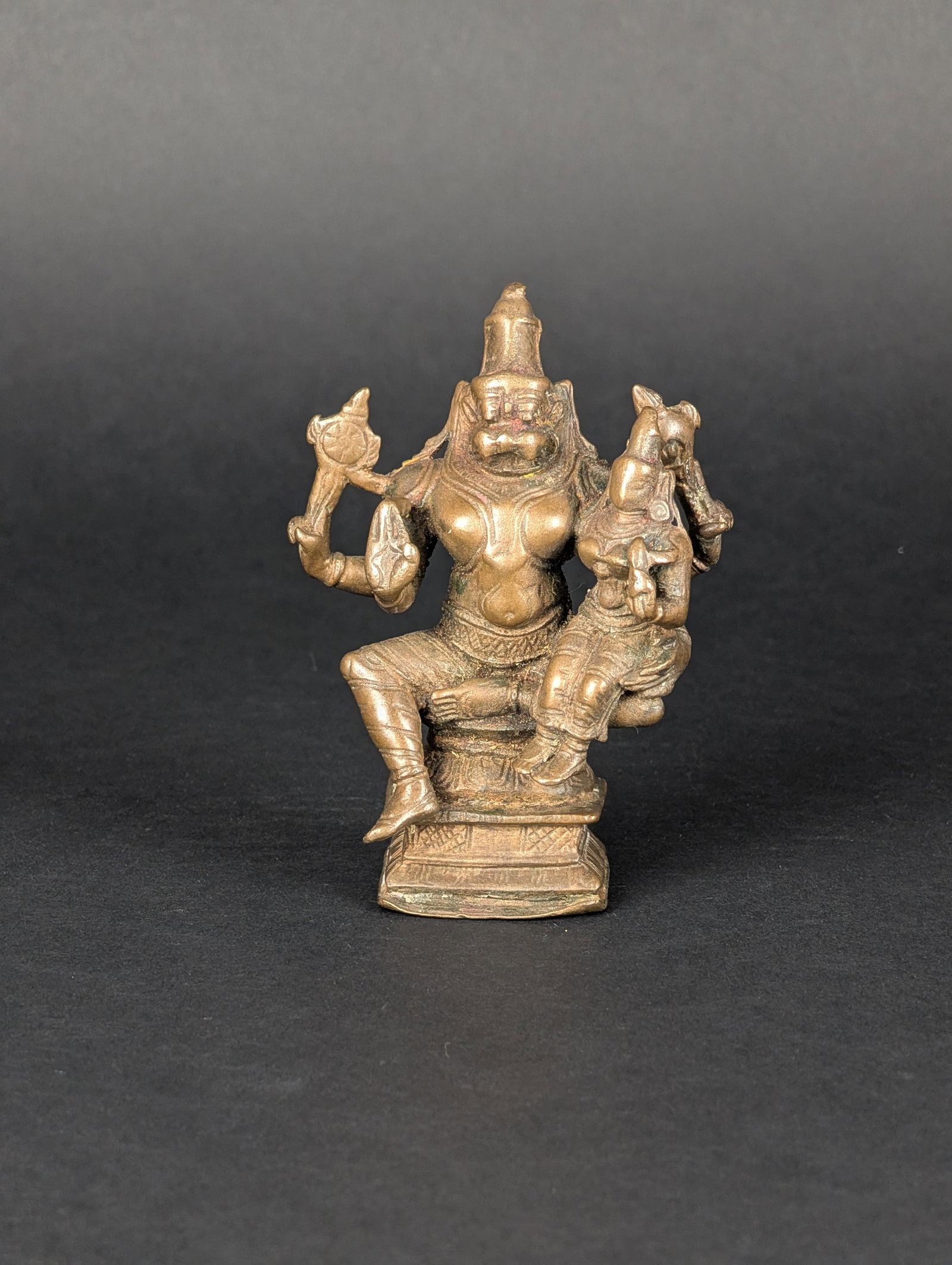 Lakshminarasimha: Narasimha is depicted here with his consort, Lakshmi. As an avatar of Vishnu, Narasimha inherits Lakshmi as his consort. Narasimha's rear hands are holding Chakra and Shankha. His lower front hand is