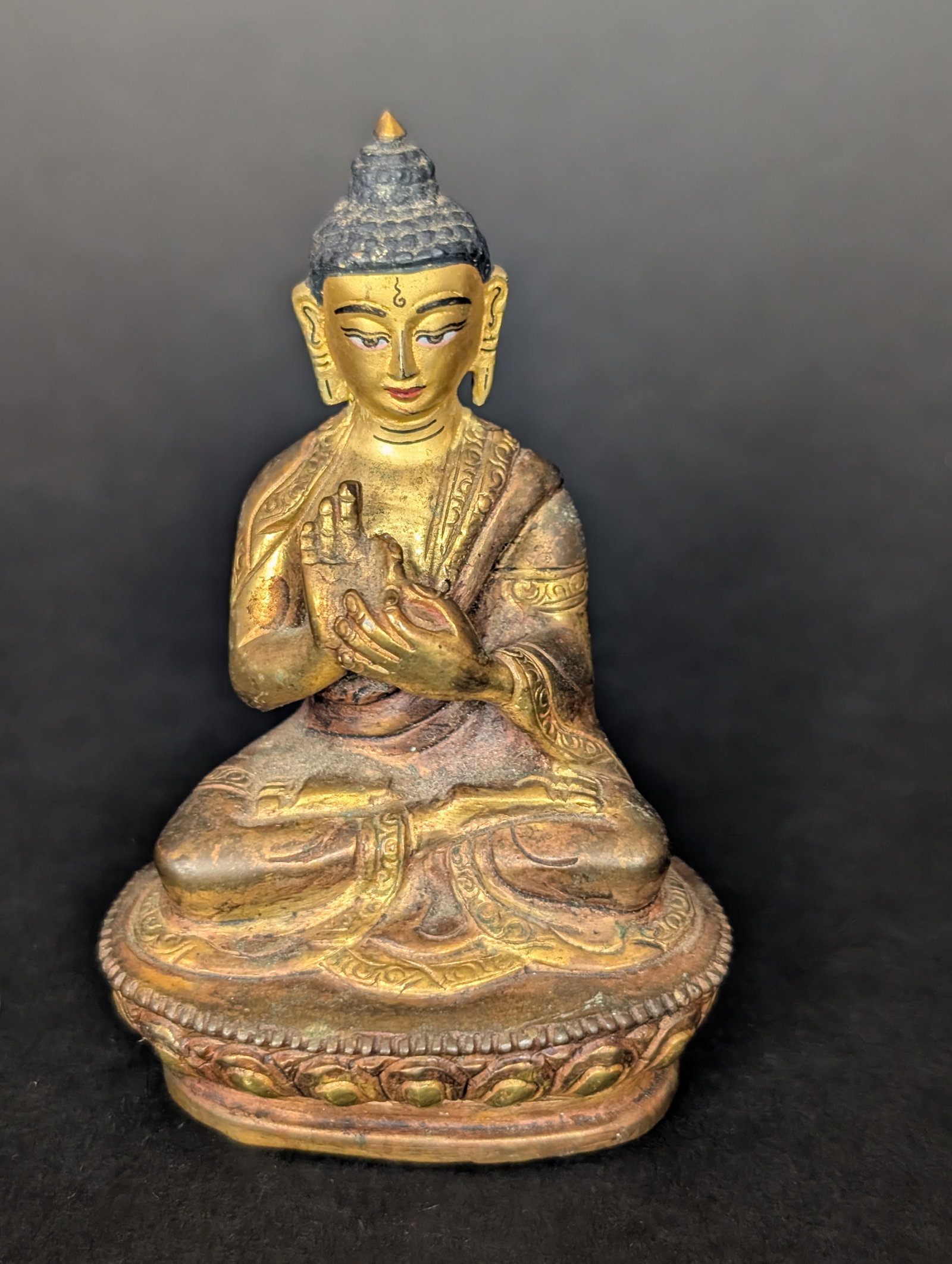 Buddha: A small Tibetan-style Buddha from Nepal. The mudra is Dharmachakra Parivartana, setting the wheels of Dharma in motion. It appears to have cold gilding, and the bottom plate is intact. Estimated age