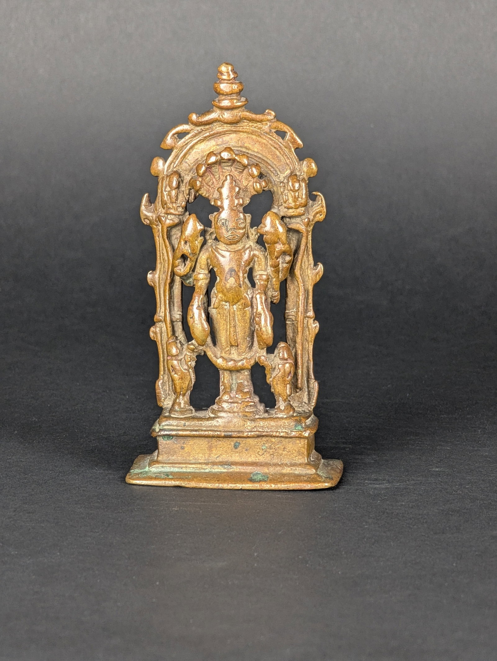 Vishnu Triad: This Vishnu group is from Central India. He is flanked by an attendant, possibly Garuda, and his consort. The deities on the top of the prabhavali verticals are not identifiable. As per the Hindu trad