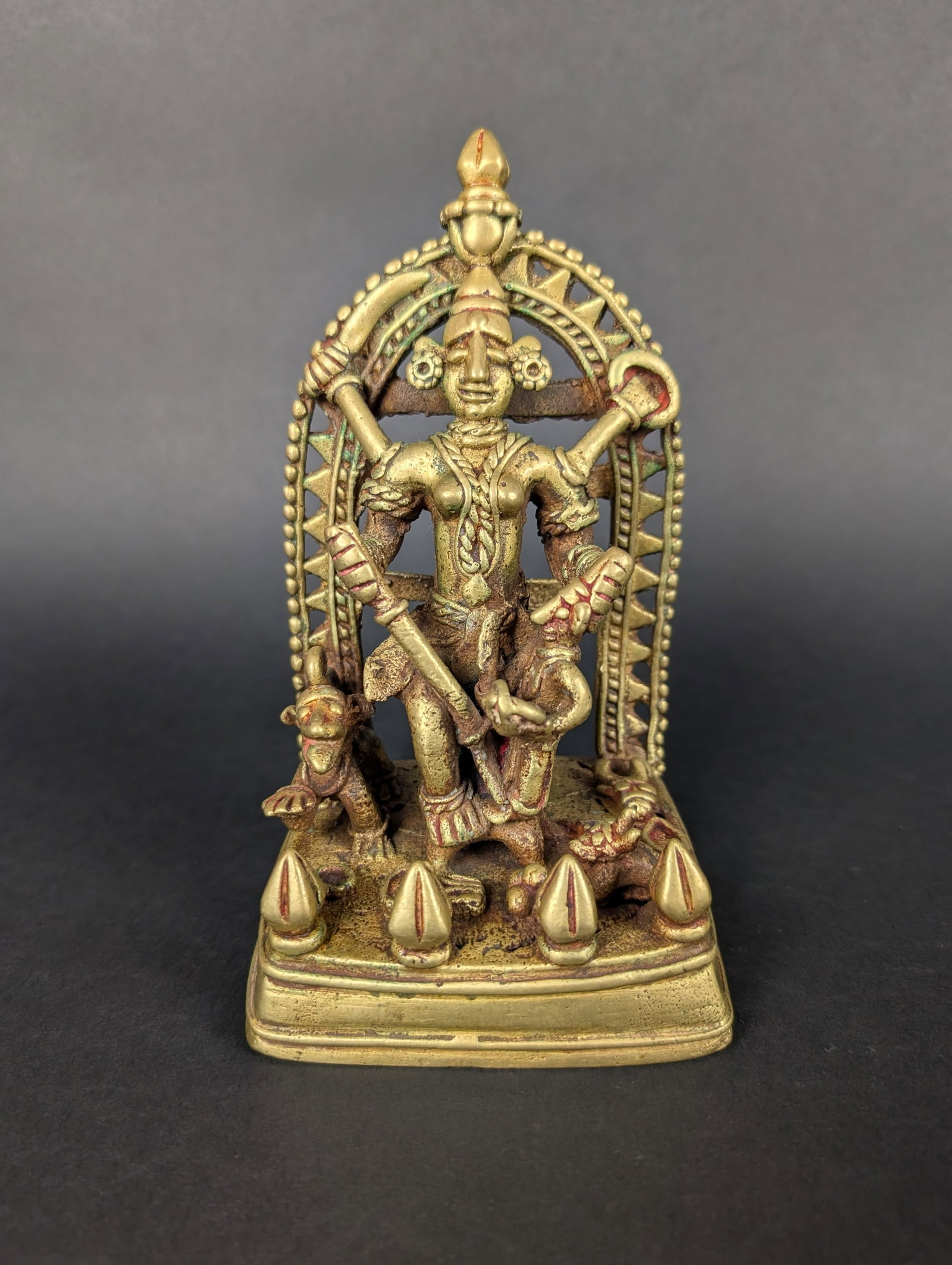 Tribal Devi, Mahishasura Mardini--Folk Icon: The iconography of Durga in the act of killing the Buffalo Demon to save the world from destruction is present here in this folk-style lost-wax casting. There are many objects at her feet, including o