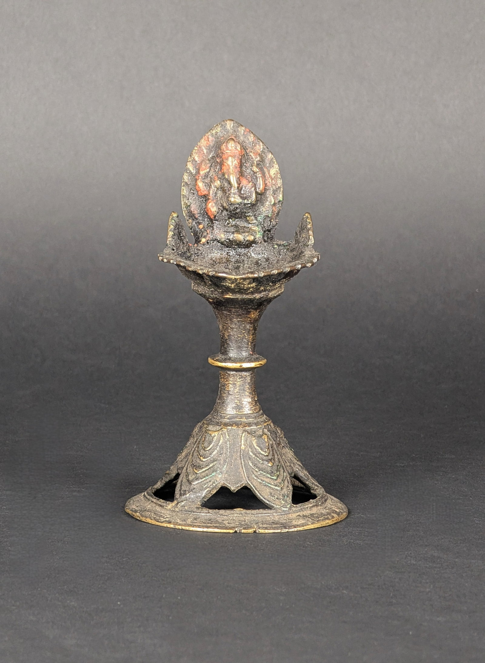 Ganesh Lamp, Nepal: This lamp has a wide base, a large oil reservoir and a Ganesha blessing the devotees. A much-used lamp. Ganesha in a dancing position is rarer. Estimated age is the 19th century. Dimensions: 5.625" H