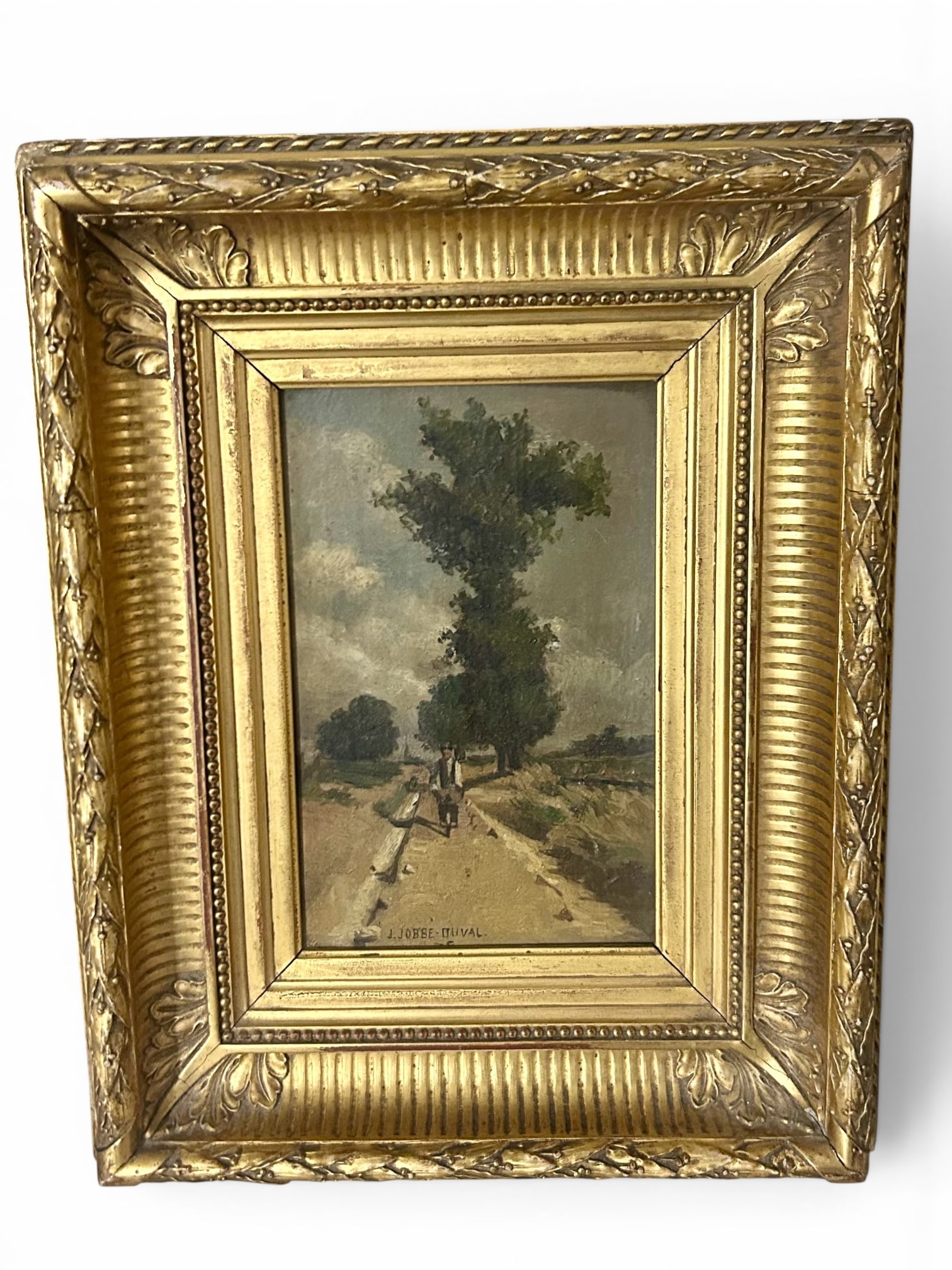 French Landscape Oil by J. Jobbe-Duval - Bicyclist on Country Path: Small oil painting signed "J. Jobbe-Duval" at lower right, depicting a bicyclist moving along a pale country path beneath tall trees and a cloud-filled sky. The French landscape is painted with loose 