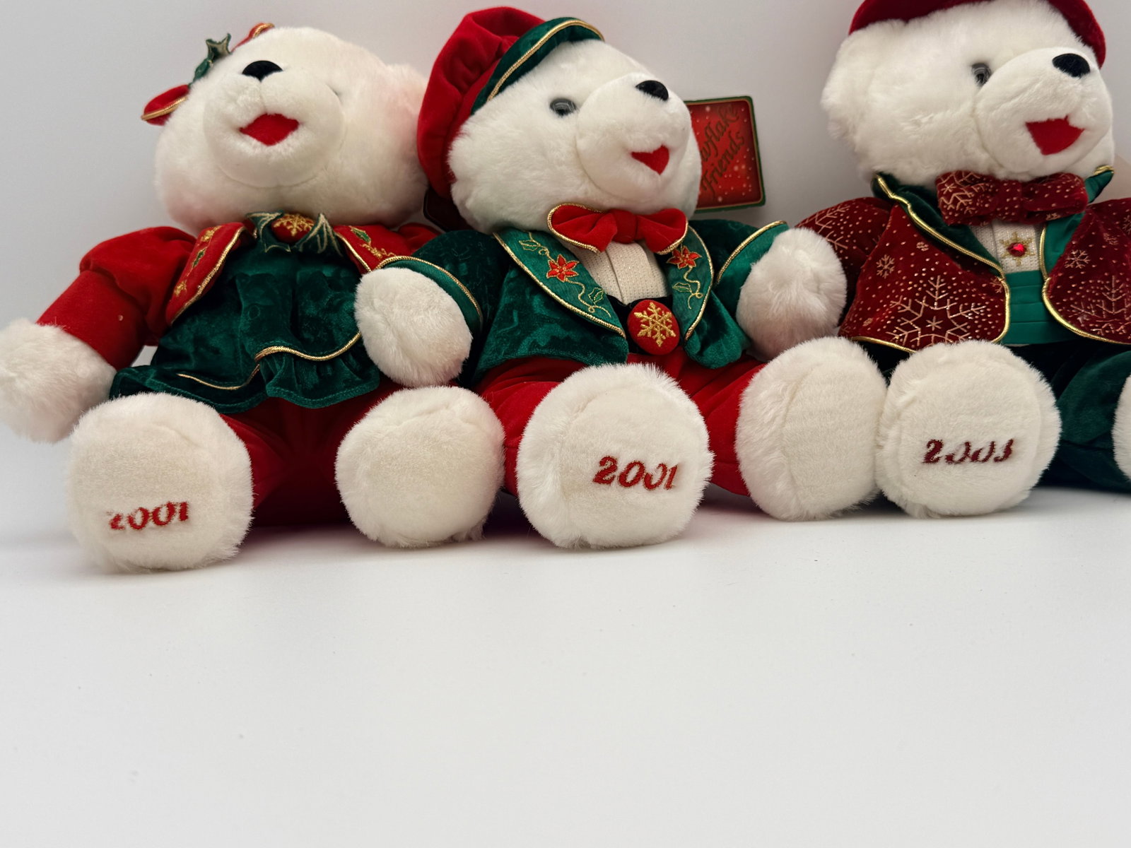 Snowflake Friends Christmas Plush Bear Trio: Lot of three Snowflake Friends holiday plush teddy bears, including girl, boy, and gentleman designs. Embroidered years 2001 and 2003. Original hang tags attached. Clean pre-owned condition with festi
