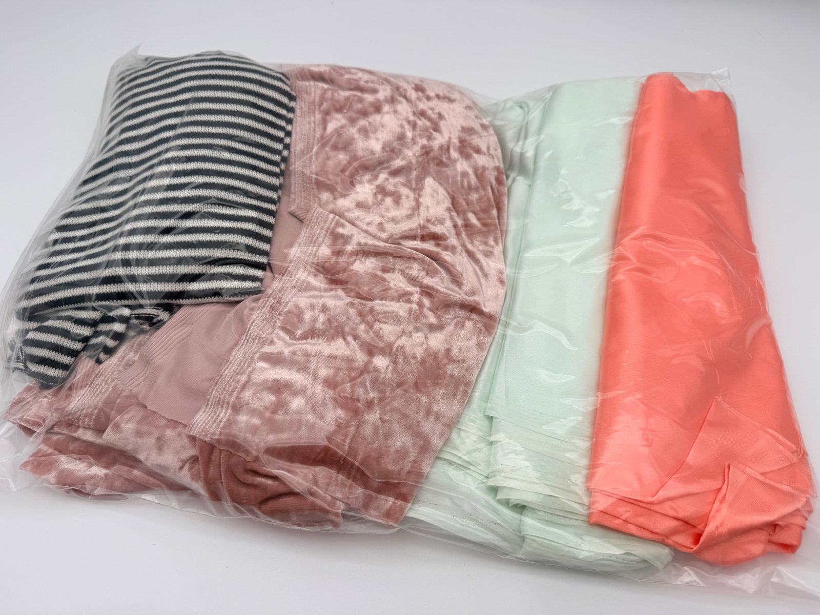 Fabric Remnant Lot: Mixed fabric pieces in assorted solids and knit textures. Age and fiber unverified.