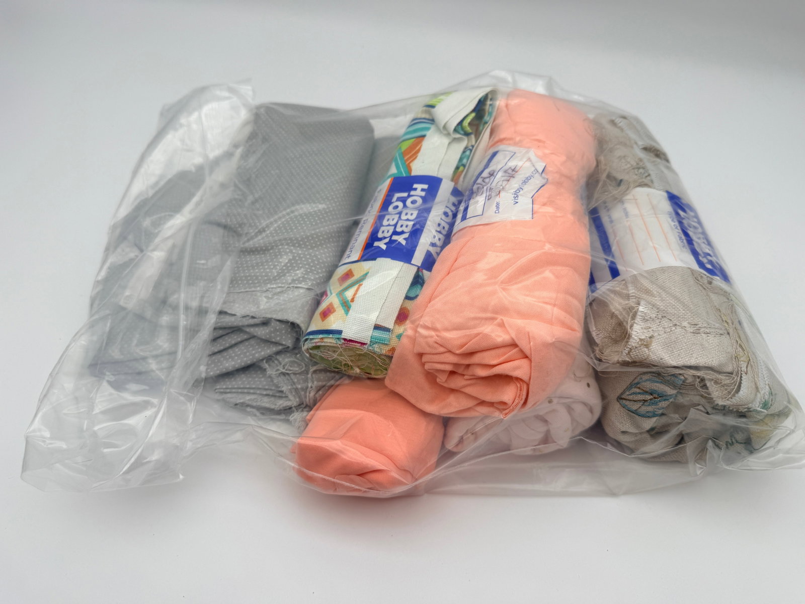Fabric Remnant Lot: Mixed fabric pieces including solids, prints, and remnants. Age and fiber unverified.